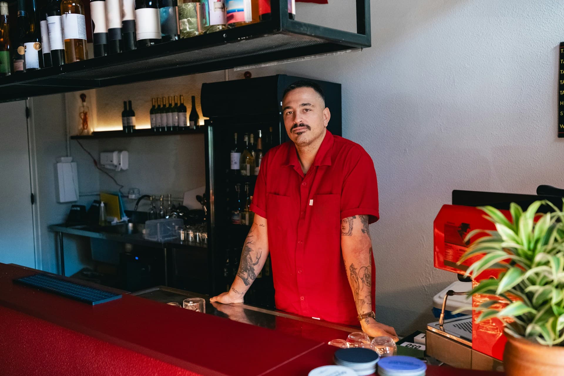 Dueño de un bar atendiendo detrás de la barra de su local